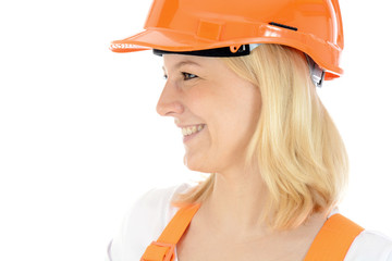 Freundliche junge Bauarbeiterin trägt Bauhelm