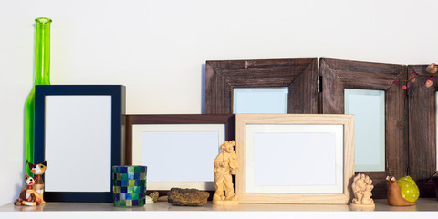 several wooden pictures frames standing on shelf