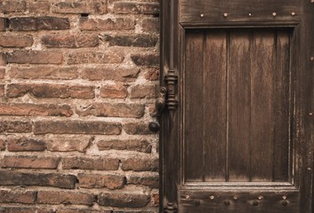 Old wooden door in brick wall