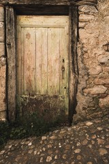 Old wooden door in stone wall