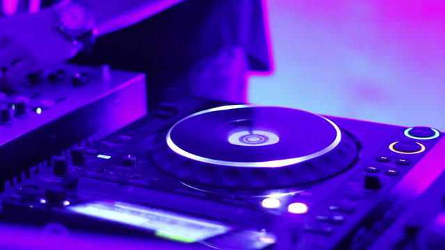 Dj behind the deck is tweaking mixer track controls scratches pl
