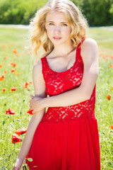 Naklejka na ściany i meble beautiful blonde girl in poppies field