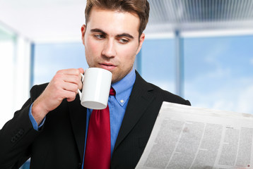 Young businessman reading a newspaper