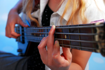 Obraz premium young girl playing bass guitar on the stage