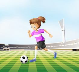 Fototapeta premium A young girl playing soccer at the field