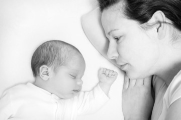 mother watching her month old son sleeping, B&W image