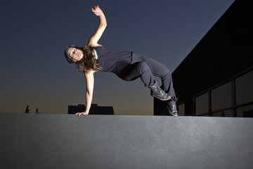 free runner doing parkour at night on a rooftop