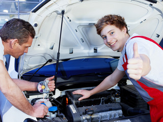 Apprentices for car mechanic is satisfied with his job