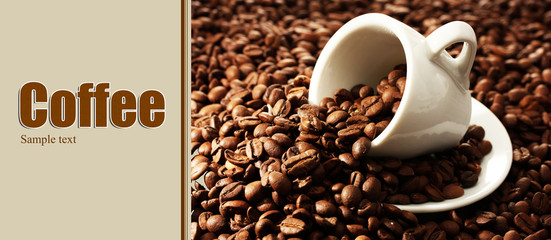 Cup of coffee on coffee beans close-up background