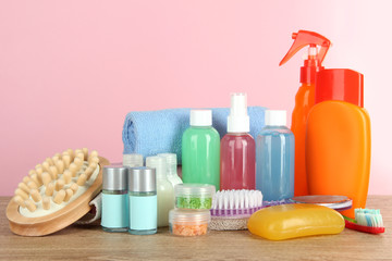 Hotel amenities kit on table on pink background
