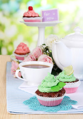 Beautiful cupcakes on dining table on natural background