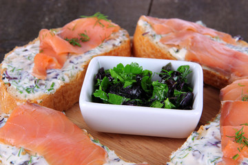Fish sandwiches on cutting board on wooden table