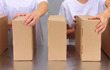 Workers working with boxes at conveyor belt, on grey background