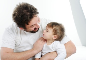 Happy young man holding a smiling 4-5 months old baby, isolated