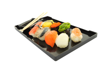 Sushi black rectangle plate focus near on white table.