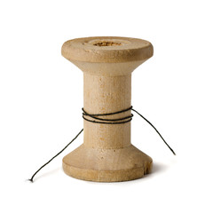 Old wooden spool with leftover threads