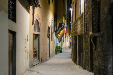 Medieval alley illuminated by street lamps, Florence