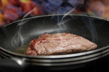 steaming steak in a pan