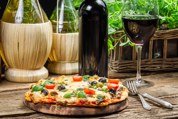 Homemade baked pizza served with wine