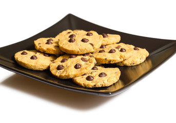 Chocolate chip cookies on a black plate isolated on white backgr