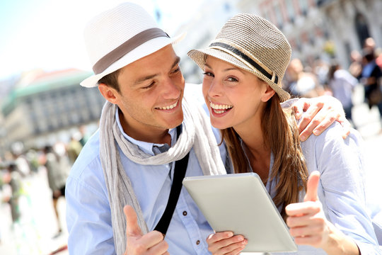 Couple with tablet showing thumbs up