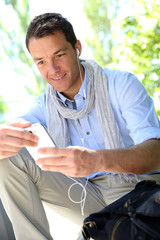 Handsome guy using smartphone and earphones