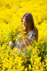 Naklejka na ściany i meble Girl in the field of yellow flowers
