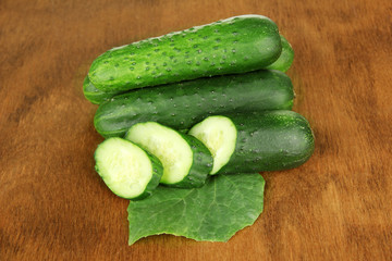 Tasty green cucumbers on wooden background