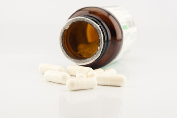 White capsule and brown bottle background