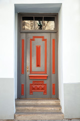 Gray wooden door with red decoration elements