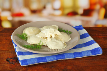 Tasty dumplings on plate, on wooden table