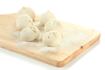 Raw khinkali on wooden desk, isolated on white