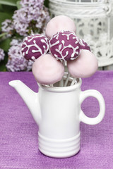 Purple and lilac cake pops in white ceramic jug, birthday party.