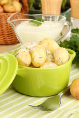 Tender young potatoes with sour cream and herbs in pan