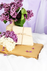 Composition with lilacs on light fabric background