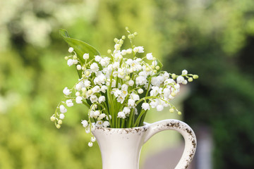 Lilly of the valley flowers in white rustic vase