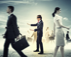 Businessman in blindfold among group of people