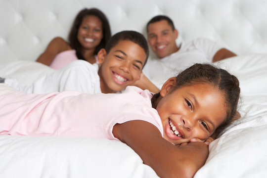 Family Relaxing In Bed Together