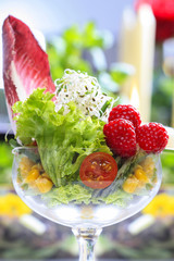 Glass goblet of fresh salad made of fruits and vegetables. Party