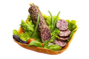 Ripe salami with salad, basil, onion and tomato