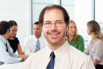 Portrait Of Businessman Sitting At Boardroom Table