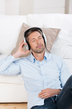 entspannter mann hört zuhause musik