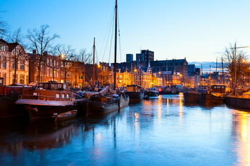 frozen canal with ships in Groningen in dusk - obrazy, fototapety, plakaty