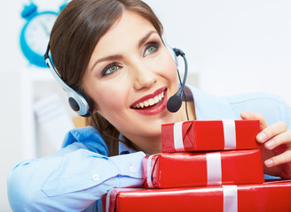 Smiling operator seat at table with red gift box. Happy busines
