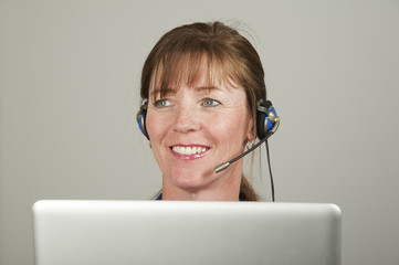 Woman using a headset and computer