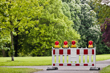 Eine Absperrbake im in gr&uuml;ner Parklandschaft