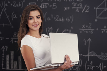 Female student with laptop in her hands .