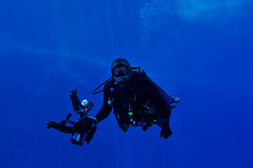 Fototapeta na wymiar Underwater photographer with big camera and flashes