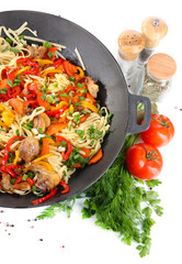 Noodles with vegetables on wok isolated on white