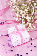 Fototapeta na wymiar Flowers and gift box on pink background